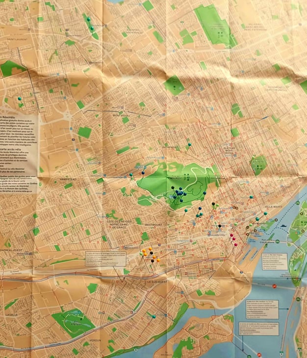 Photographie d’une carte de la ville de Montréal et de plusieurs punaises.